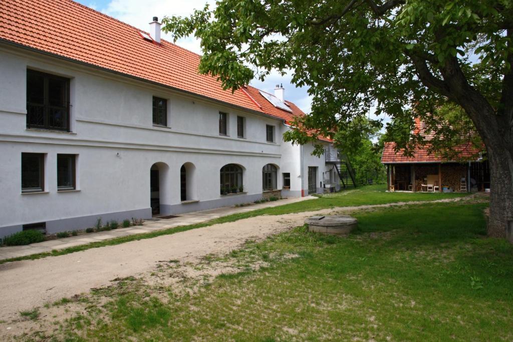 een groot wit gebouw met een boom in de tuin bij Ubytování na statku in Vědomice