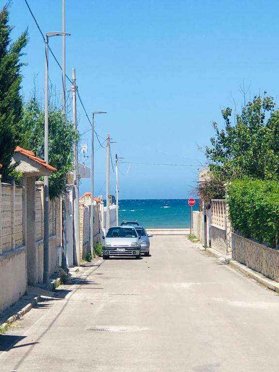 a car parked on a street next to the ocean at Relax House in Bari