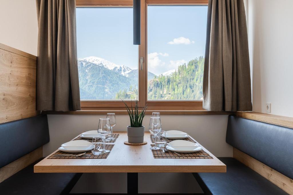 einen Tisch in einem Zimmer mit einem großen Fenster in der Unterkunft Alpinence in Ulten