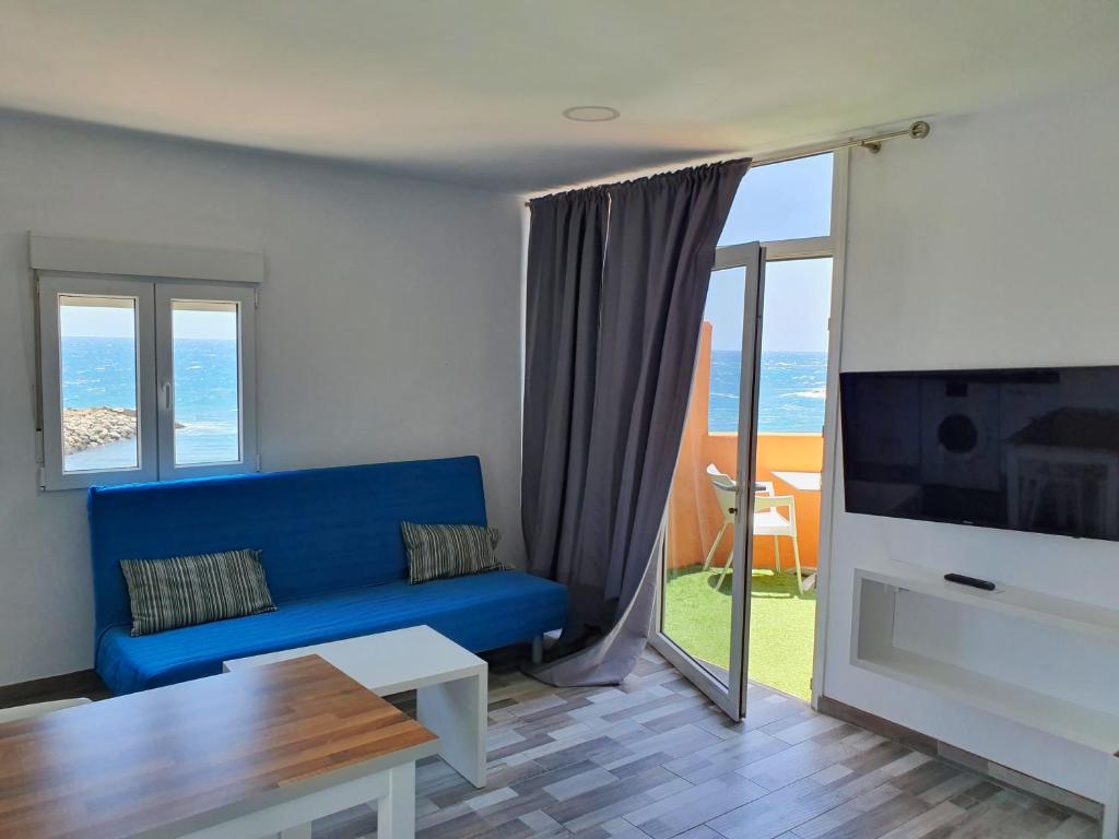 ein Wohnzimmer mit einem blauen Sofa und einem TV in der Unterkunft pozo in Pozo Izquierdo