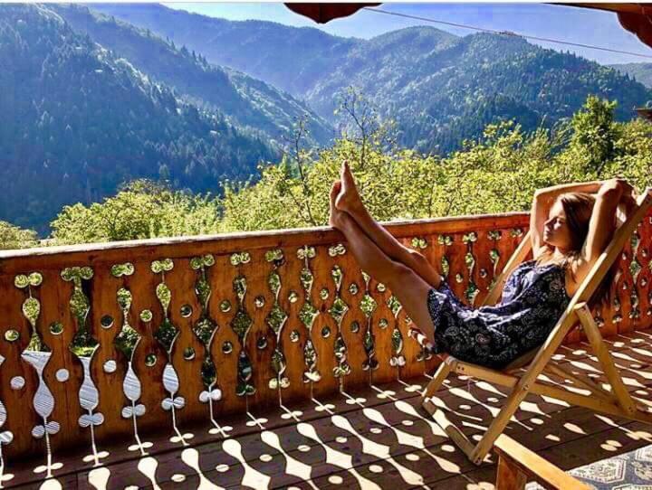 a woman sitting in a chair on a porch with a view at Guesthouse in Utsera in Utsera