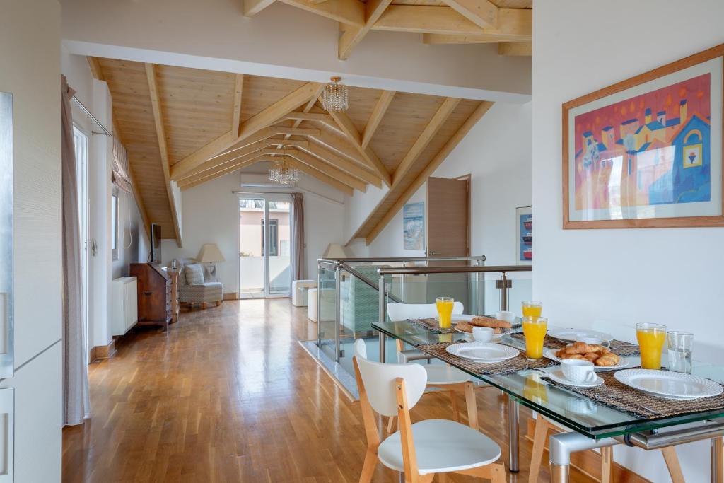 una sala da pranzo con tavolo in vetro e sedie di Elegant Living ad Argostoli