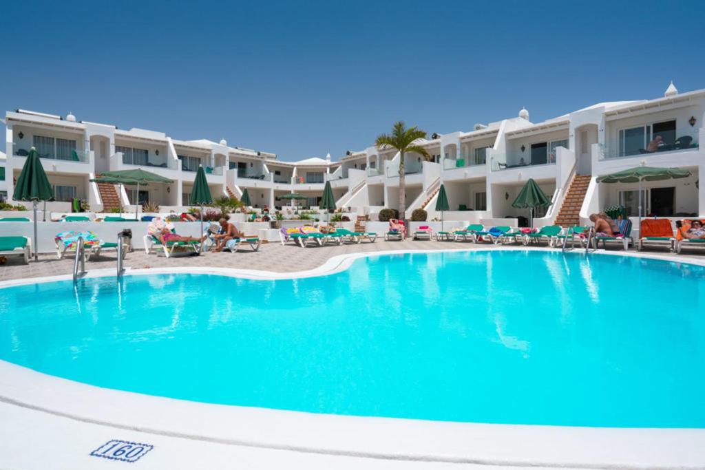 a swimming pool in front of a resort at Apartamentos Princesa Guayadeque in Puerto del Carmen