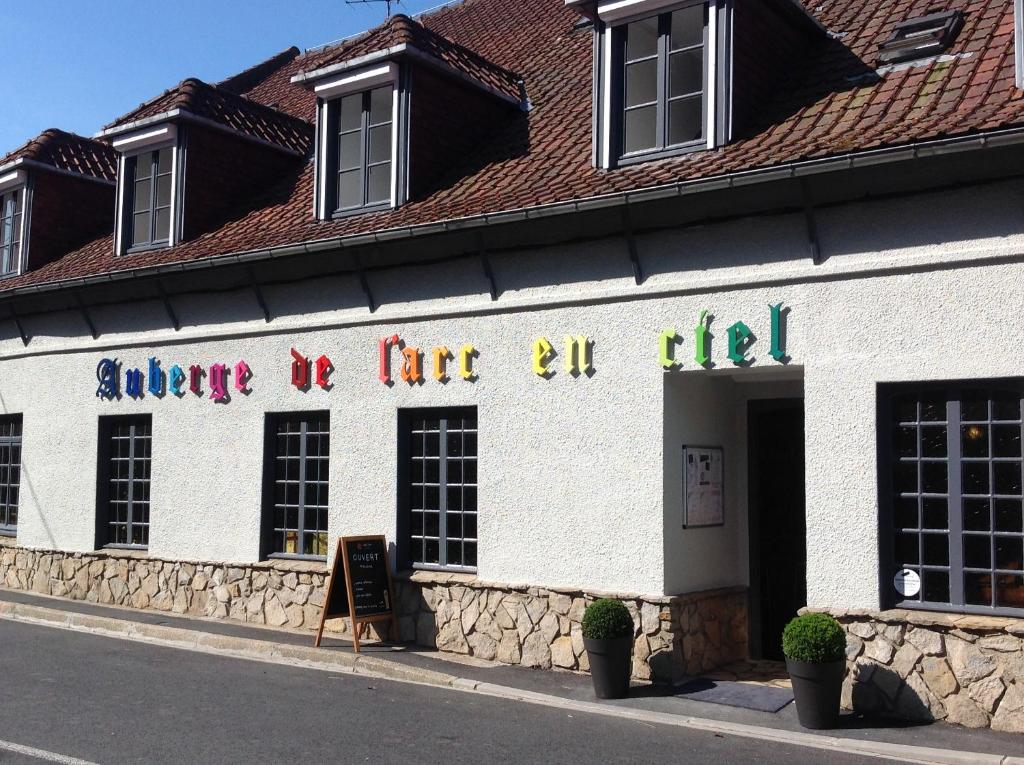 a white building with a sign on the side of it at Auberge de l'Arc en Ciel in Fauquembergues
