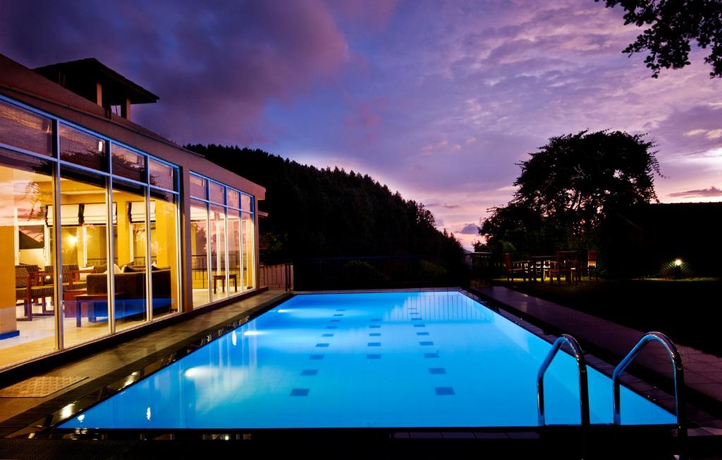 een zwembad voor een huis 's nachts bij Melheim Kandy Villas in Kandy