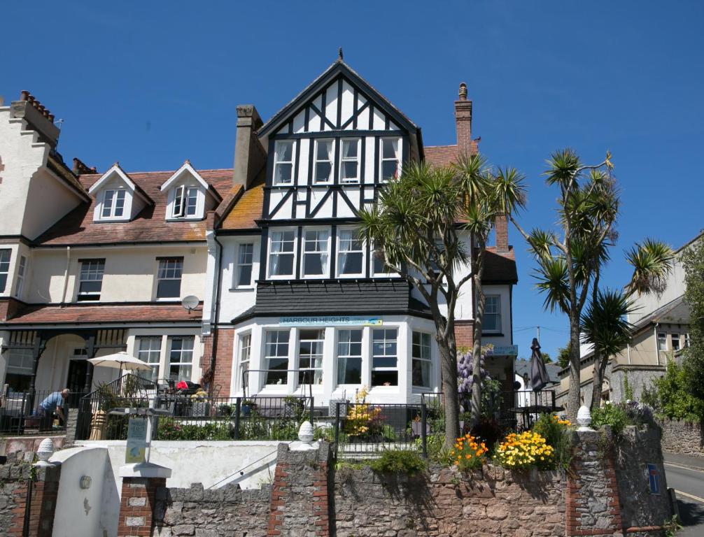 una casa bianca e nera con una palma di fronte di Harbour Heights Guest House a Torquay