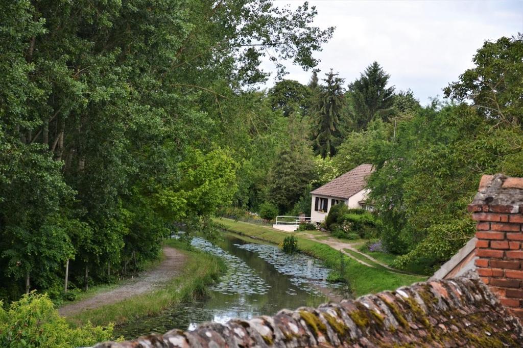 a house next to a river with a brick wall at Chambres d'hôtes Châtres-Sur-Cher in Châtres-sur-Cher