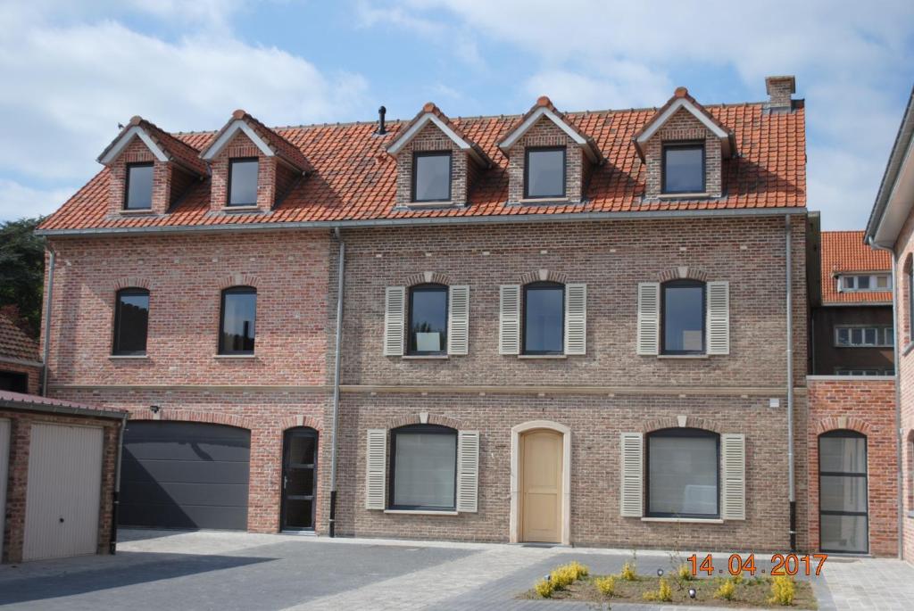 una casa de ladrillo con techo rojo en Le Triporteur Gite, en Comines