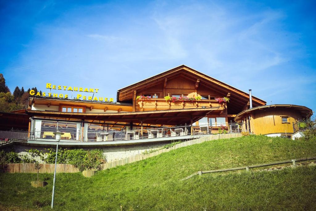 ein großes Holzgebäude auf einem Hügel in der Unterkunft Gasthof Pension Perauer in Lieserhofen