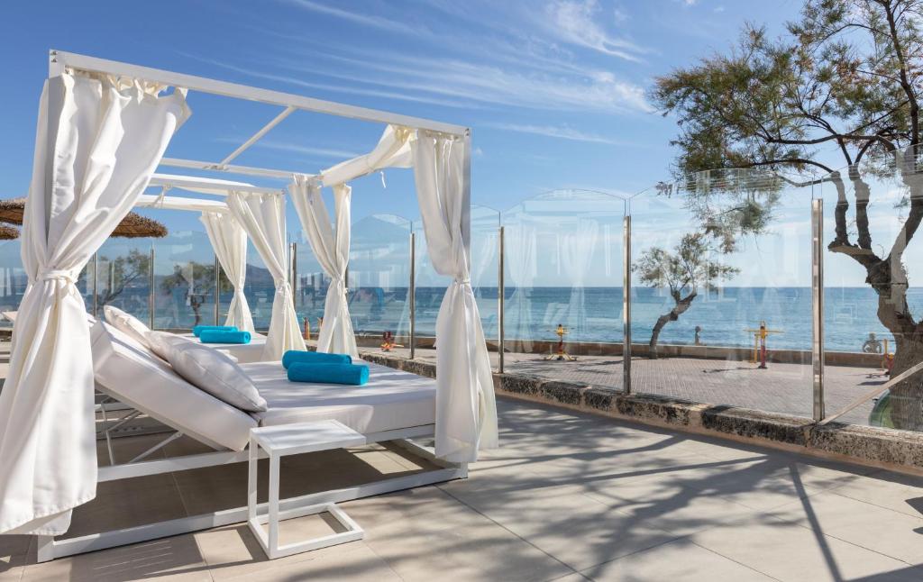 een hemelbed op een patio met uitzicht op de oceaan bij Ferrer Concord Hotel & Spa in Can Picafort