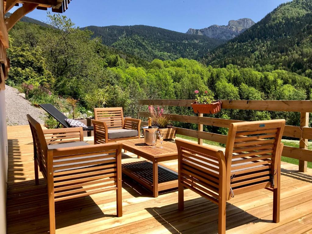 um deque com cadeiras e uma mesa com vista para as montanhas em Chalet Eterlou em Mégevette