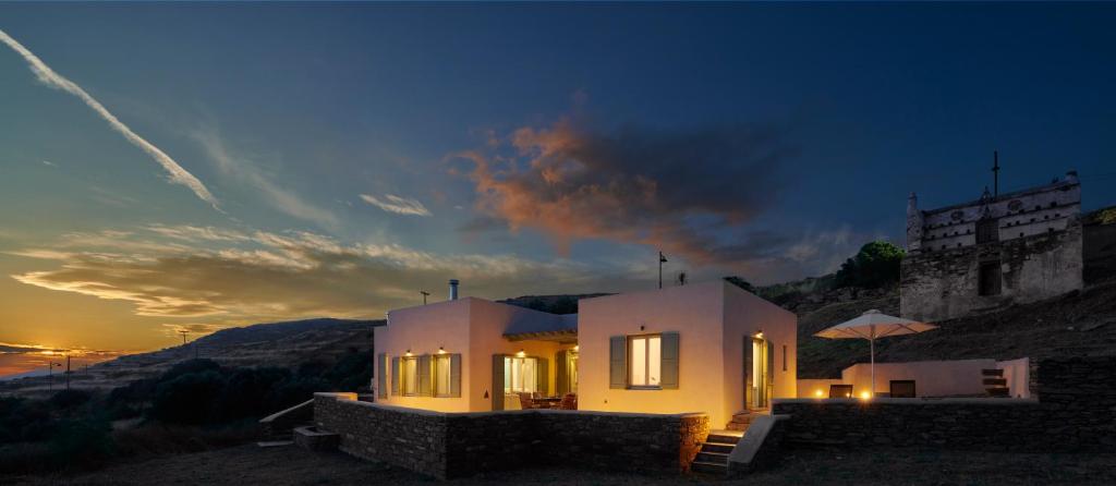 una casa con una puesta de sol en el fondo en Villa Rosa-Maria, en Tinos