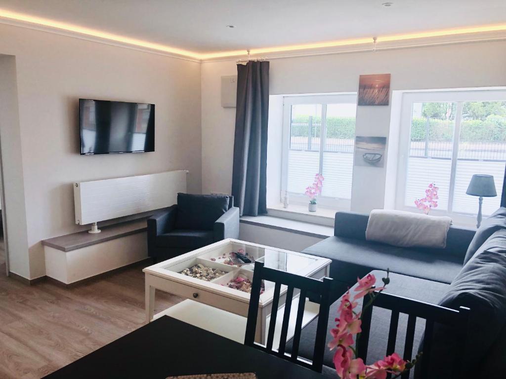 ein Wohnzimmer mit einem Sofa und einem Tisch in der Unterkunft Ferienwohnung Adriana Warnemünde in Warnemünde