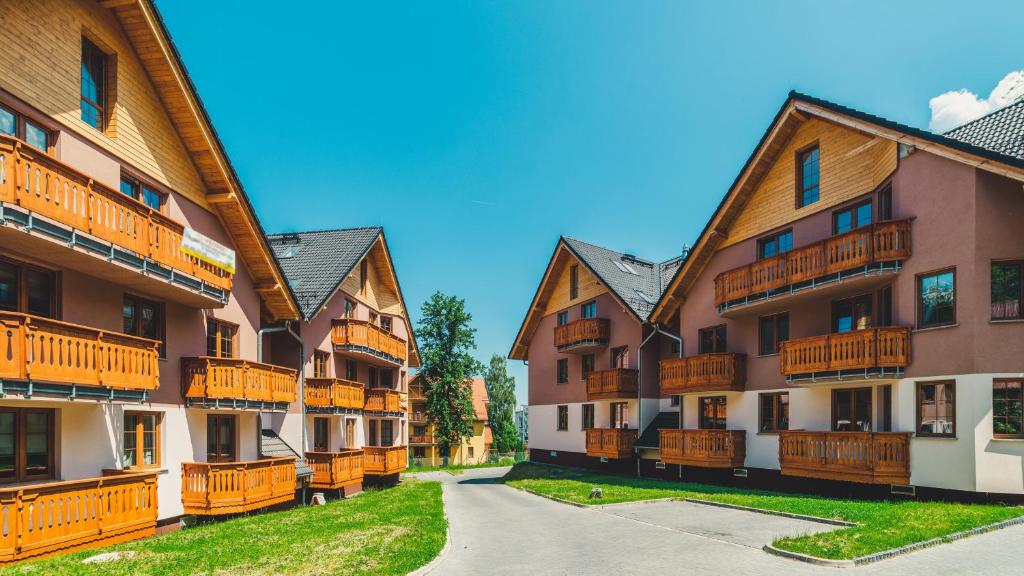 una fila de edificios de apartamentos con balcones de madera en Apartamenty Sun & Snow Karpacz Nadrzeczna, en Karpacz