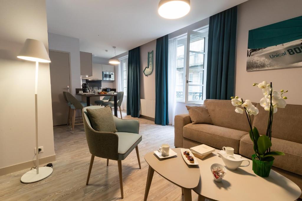 een woonkamer met een bank en een tafel bij Appartements des Marins in Saint-Malo