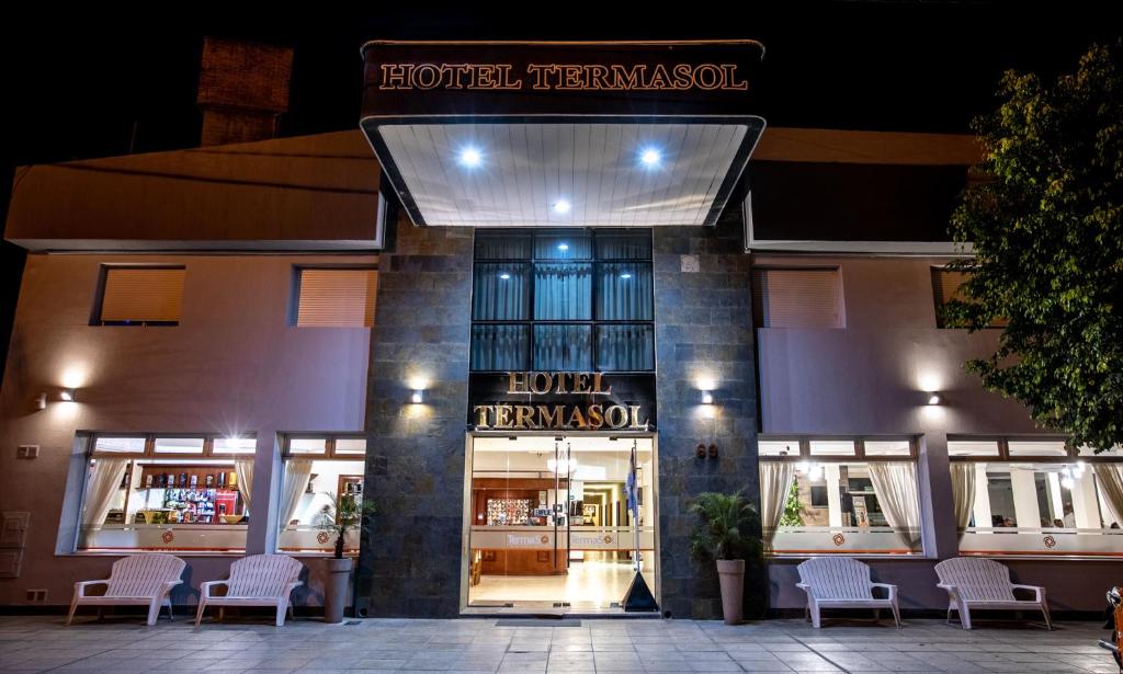 a building with chairs in front of a store at Hotel Termasol in Termas de Río Hondo