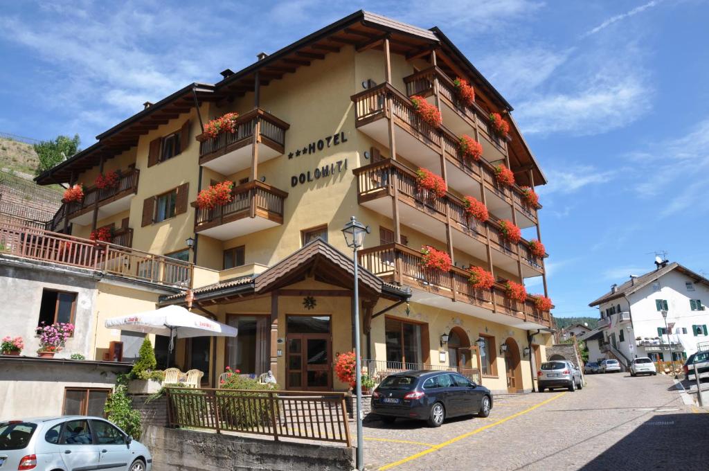 a large building with balconies and flowers on it at Albergo Dolomiti in Capriana