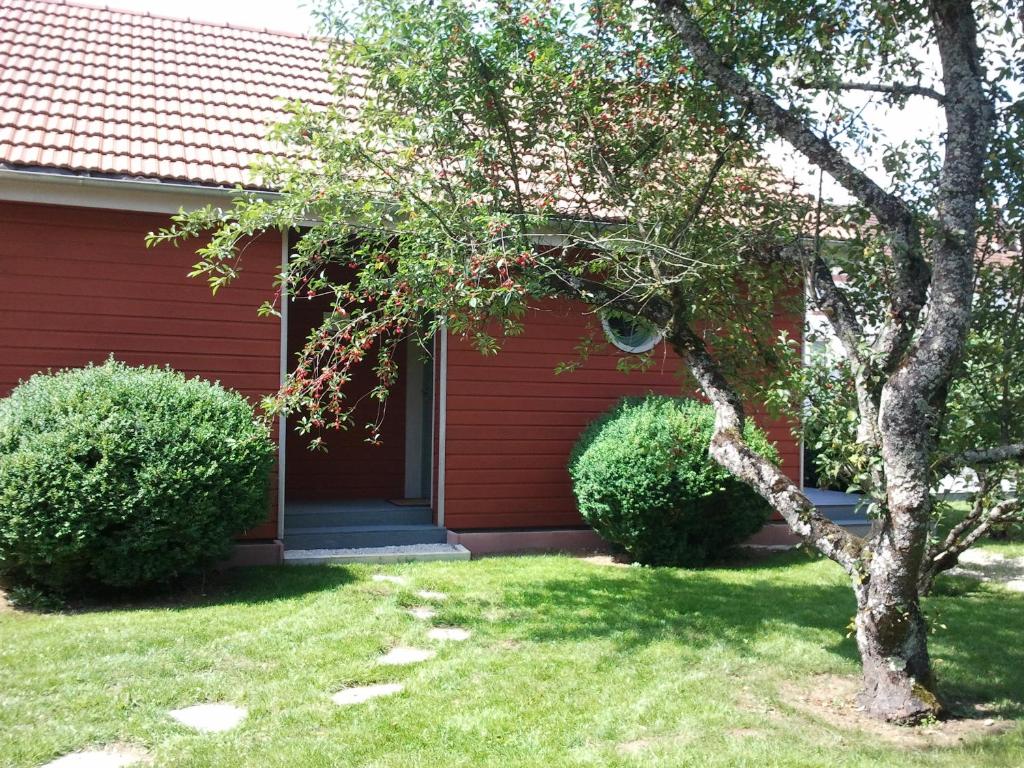 a red house with two bushes in front of it at Sous le Cerisier in Venarey-les-Laumes