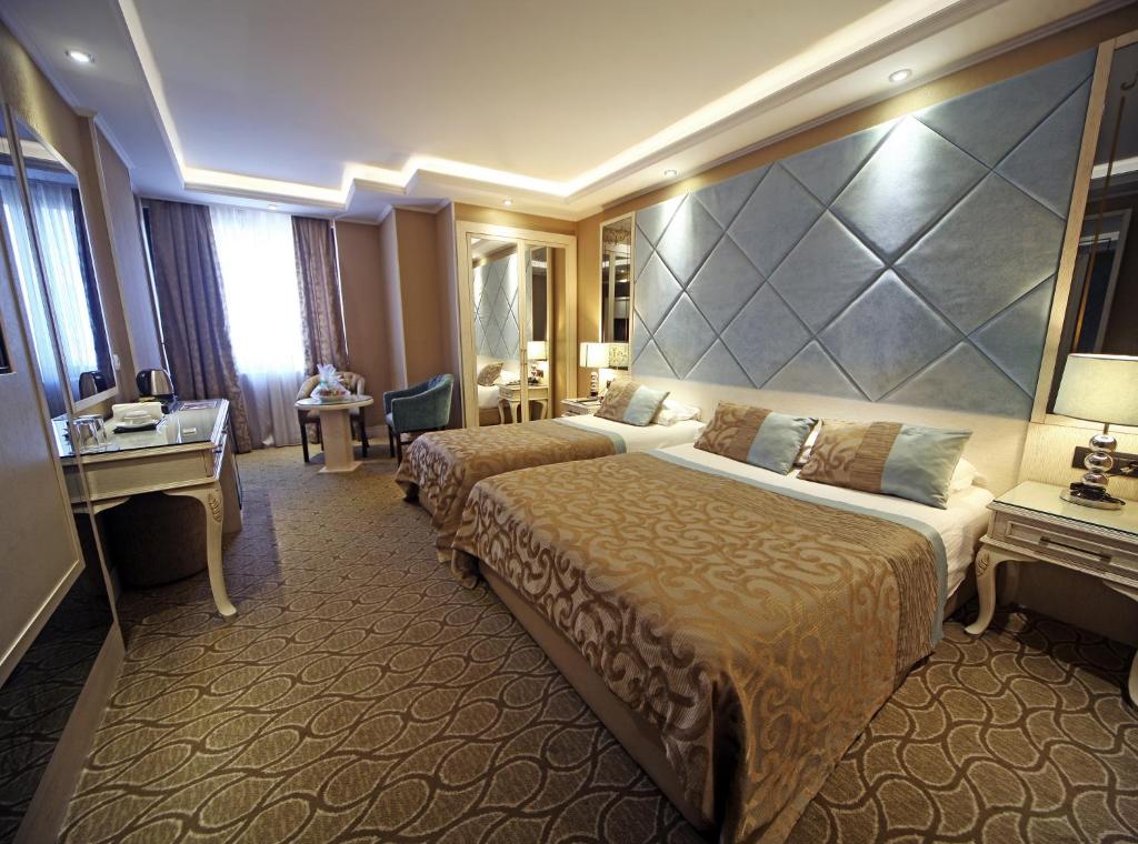Cette chambre comprend deux lits et un grand mur. dans l'établissement The Parma Hotel Downtown, à Istanbul