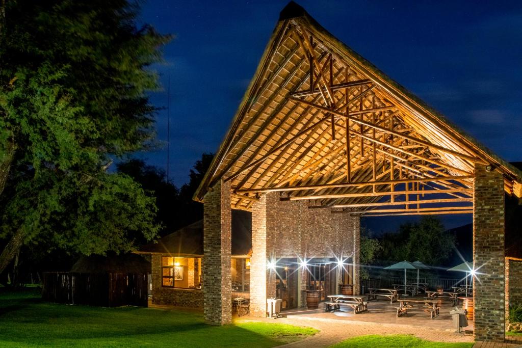 a pavilion with a picnic table in the yard at night at Elgro River Lodge in Potchefstroom
