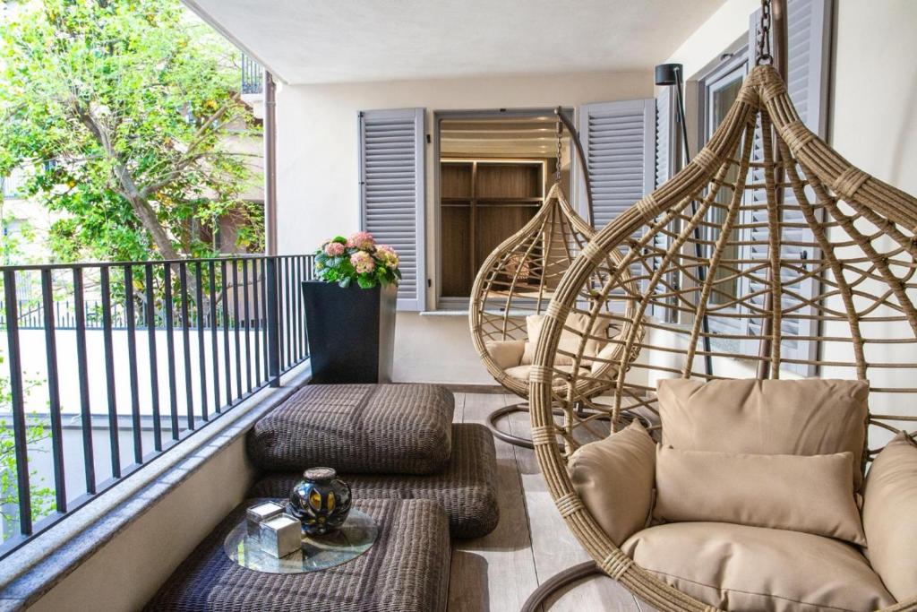 a porch with two swinging chairs on a balcony at Palazzo Rougier Milano in Milan