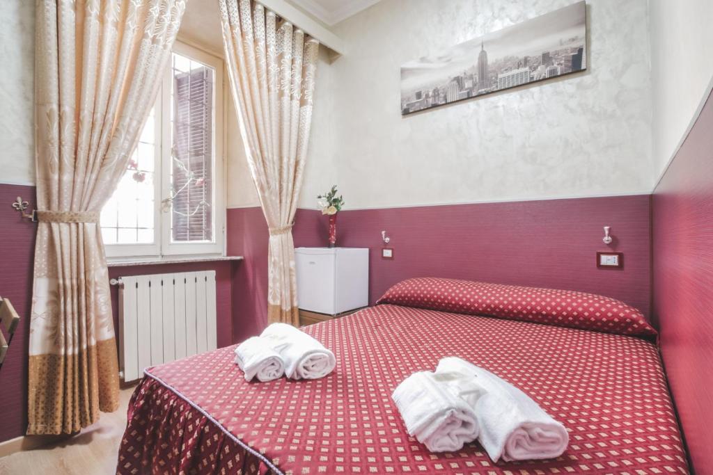 a red bedroom with two towels on a bed at Vertex Homes in Rome