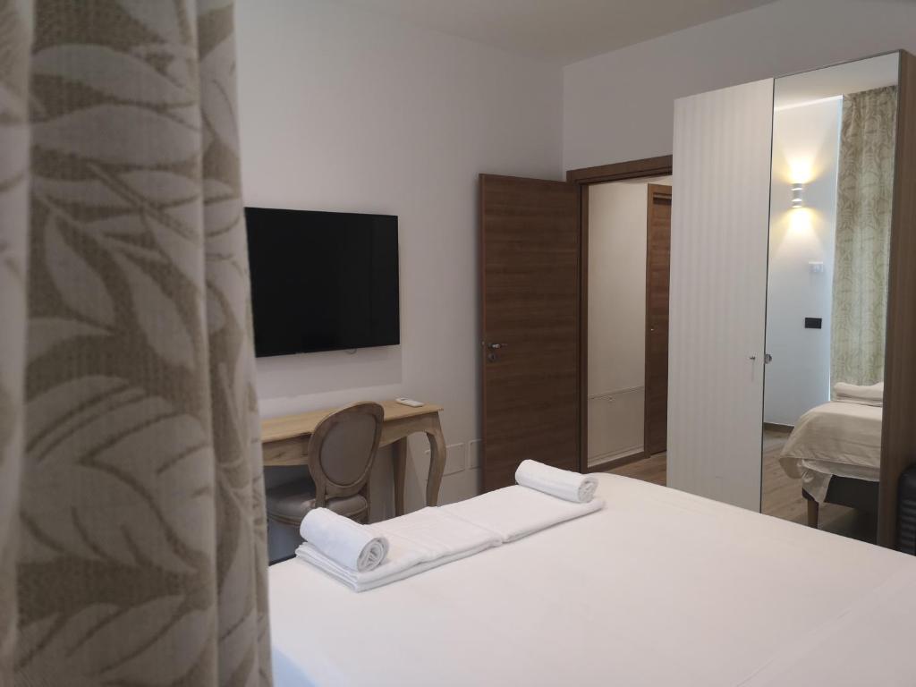 um quarto com uma cama, uma televisão e um espelho em Apartments For You em San Donato Milanese