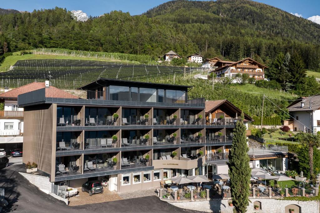 una vista aérea de un hotel con montañas en el fondo en Hotel Alpenrose, en Scena