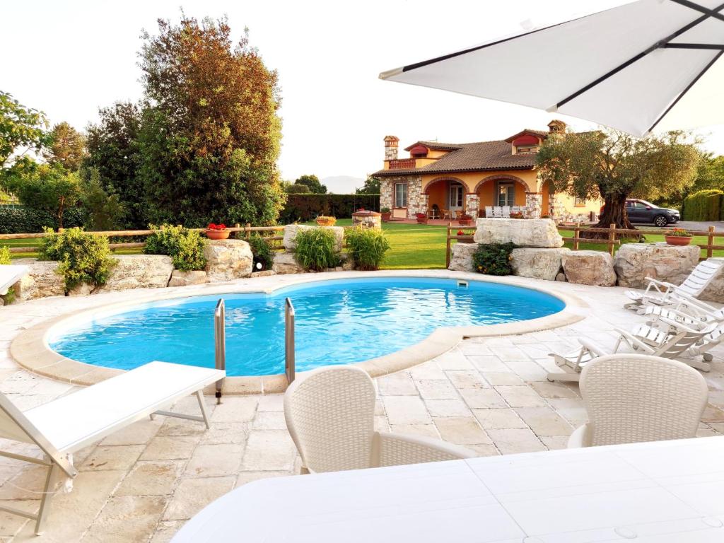 uma piscina com cadeiras e um guarda-sol em Tuscan Villa exclusive use of private pool A/C Wifi Villa Briciola em Capannori