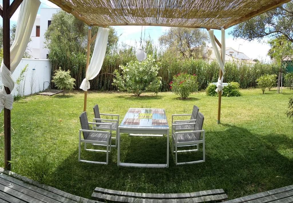 ロス・カーニョス・デ・メカにあるCasa Montecote Playaの庭のパーゴラの下にテーブルと椅子