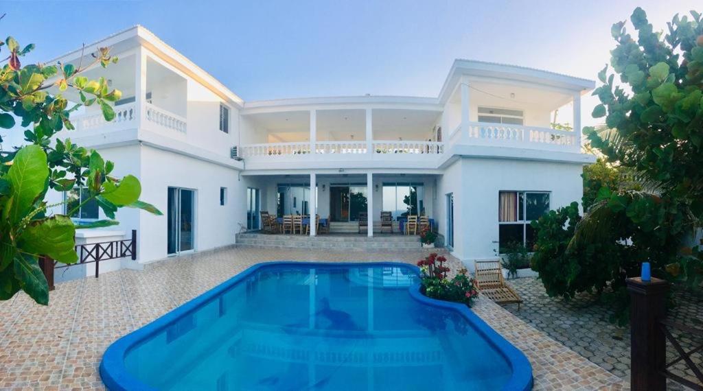 a villa with a swimming pool in front of a house at Maxanika in Jacmel