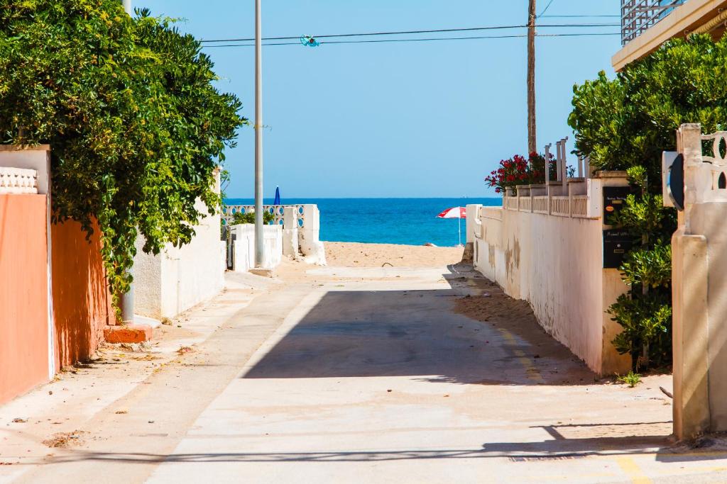 an empty street next to the beach at la casa de dias soleados in Denia