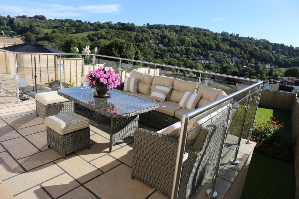 a patio with a table and chairs on a balcony at Granby in Nailsworth