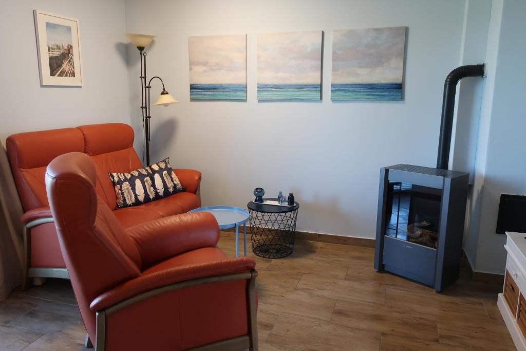 a living room with a chair and a television at Ferienwohnung BLAU in Hohenfelde