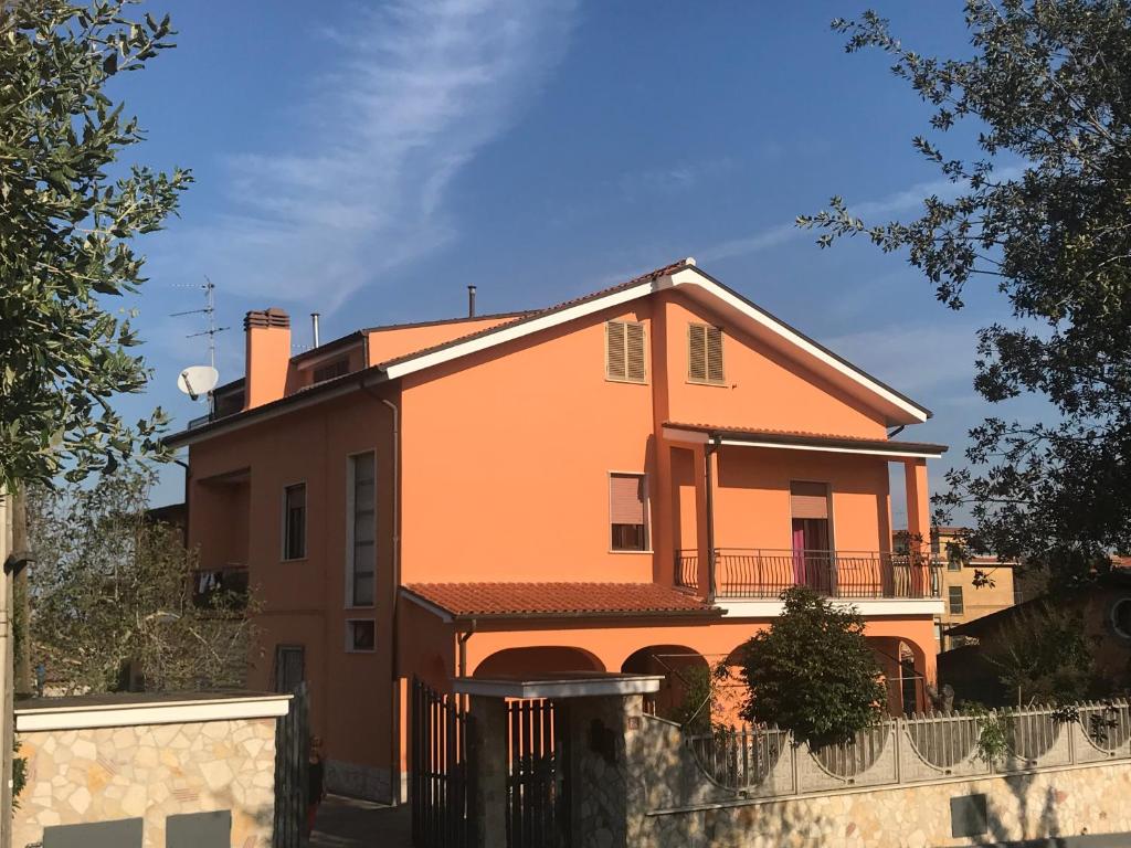 een oranje huis met een hek ervoor bij CASAMARTY in San Cesareo