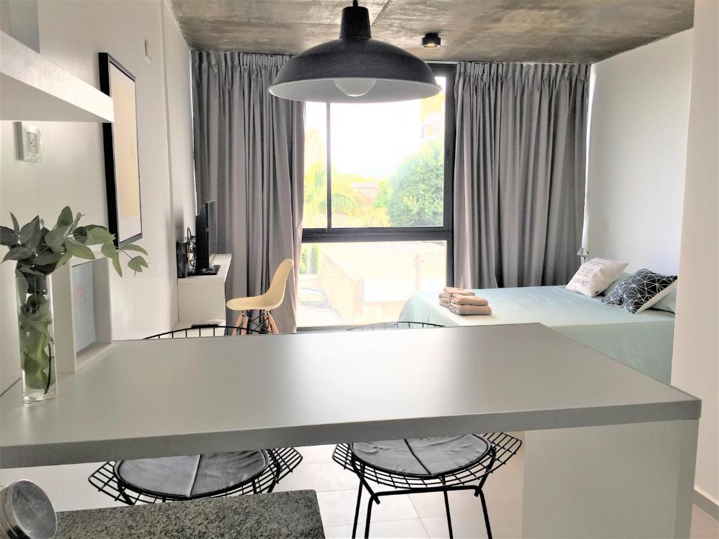 a room with a white table and chairs and a bed at Hipolito Estudio I in Belén de Escobar