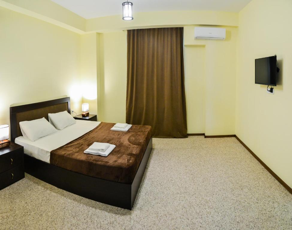 a hotel room with a bed and a television at Hotel Garden in Tbilisi City