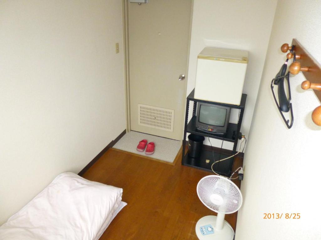 a small room with a bed and a tv at Hotel Diamond in Osaka