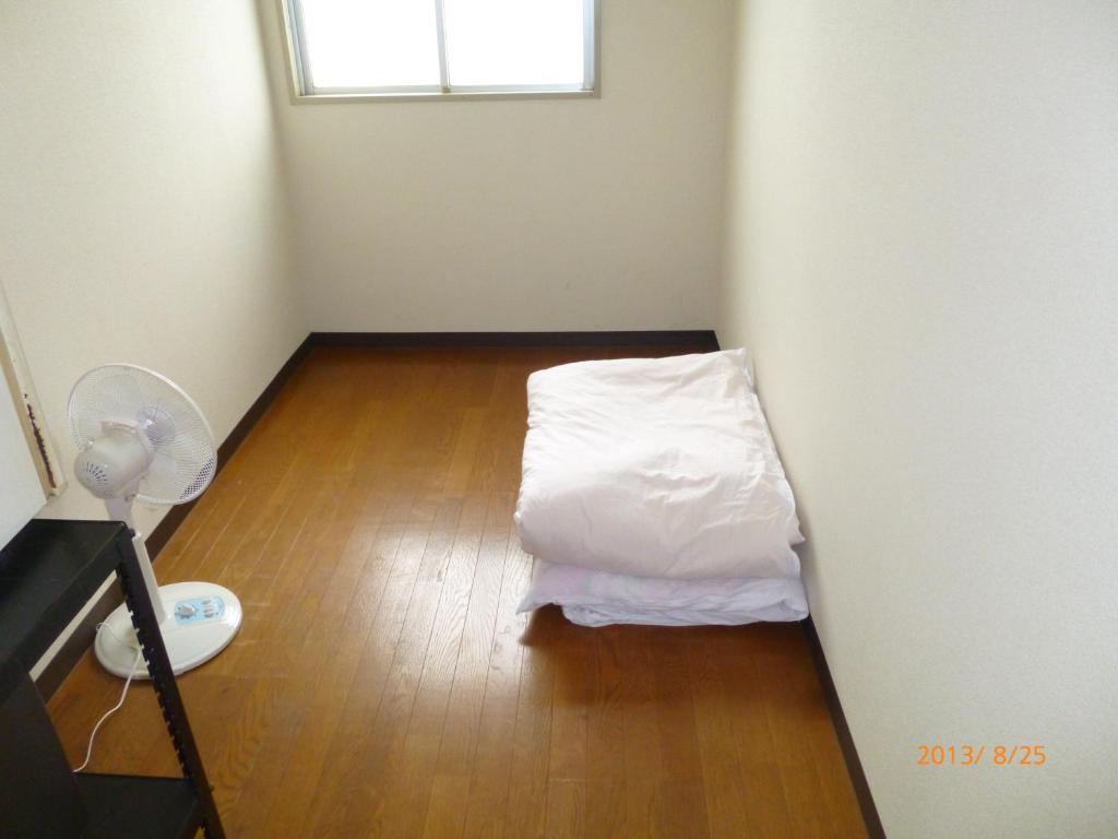a small room with a white bed and a window at Hotel Diamond in Osaka