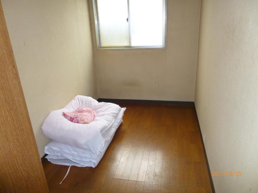 a room with a bed in the corner with a window at Hotel Diamond in Osaka