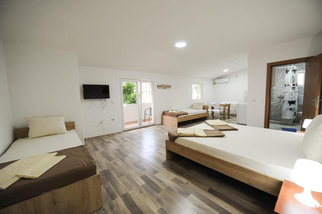 a large room with two beds and a television at Stella Apartments in Gevgelija