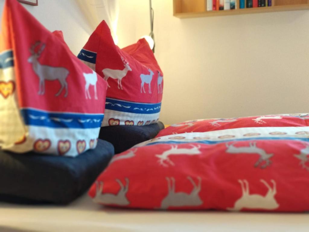 ein paar rote Kissen auf einem Bett in der Unterkunft Haus am Wiesenrain in Leutasch