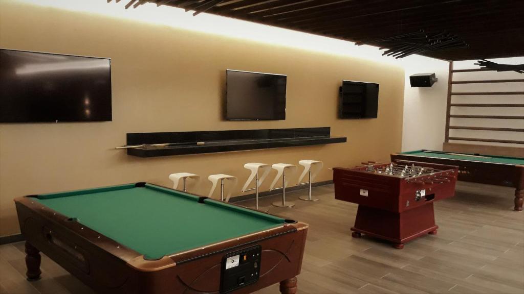 a room with two pool tables and a flat screen tv at Hipotels Barrosa Park in Chiclana de la Frontera