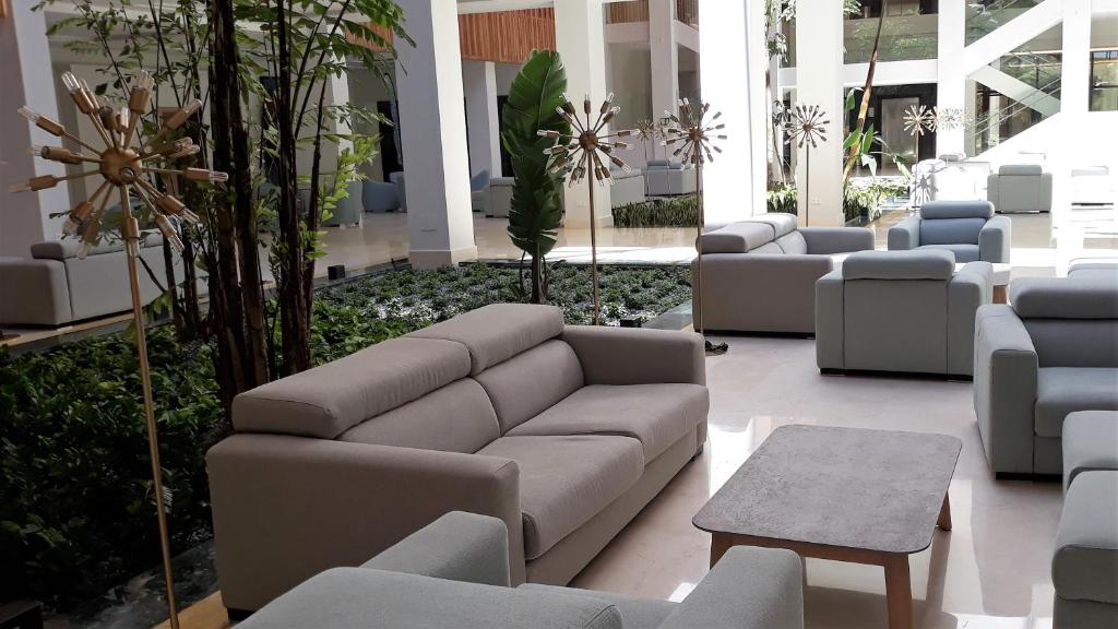 a lobby with a couch and chairs in a building at Hipotels Barrosa Park in Chiclana de la Frontera