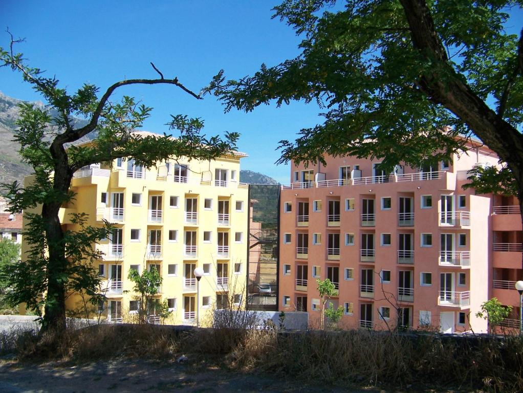 a group of buildings with trees in the foreground at Vanina Park in Corte