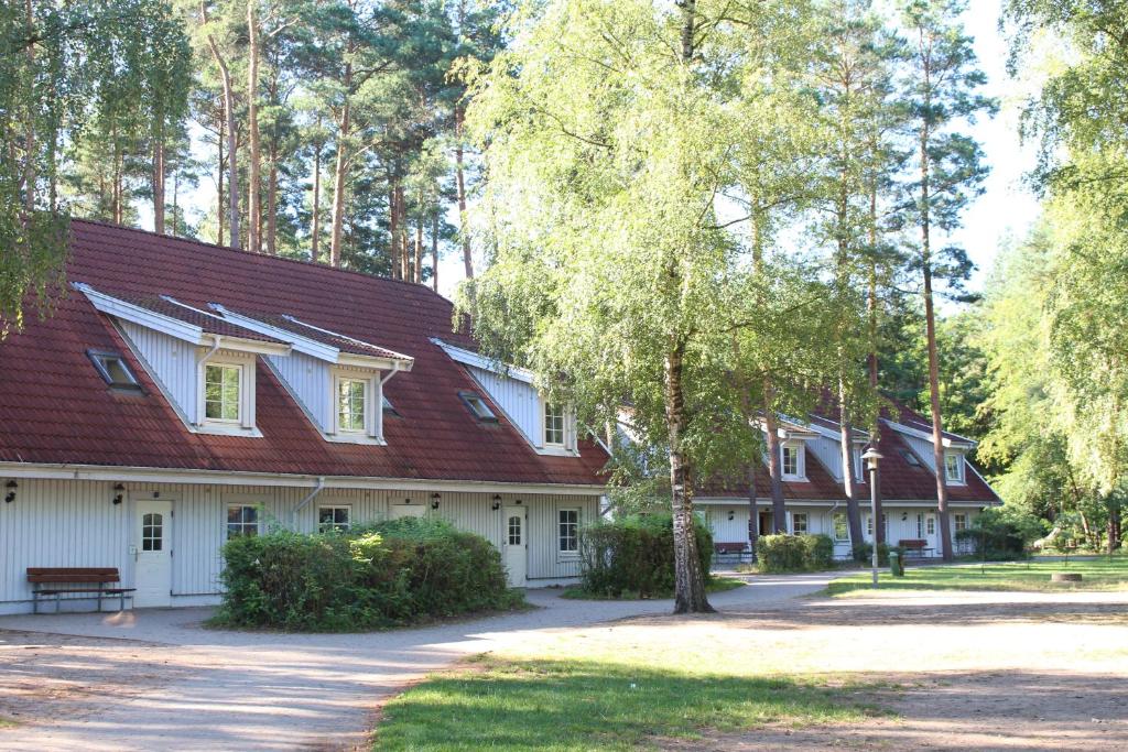 Casa blanca con techo rojo y árboles en martas Gästehäuser Groß Väter See, en Templin