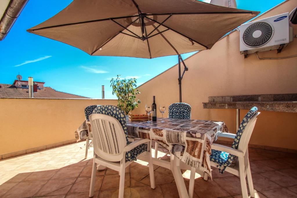 a table and chairs with an umbrella on a patio at Apartment Nada in Pula