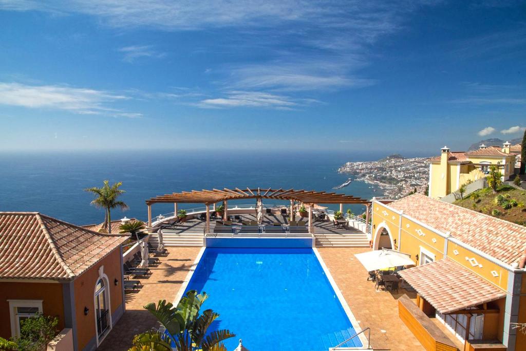 a swimming pool with a view of the ocean at Balancal Apartments and Villas Palheiro Village by Holiday Rental Madeira in Funchal