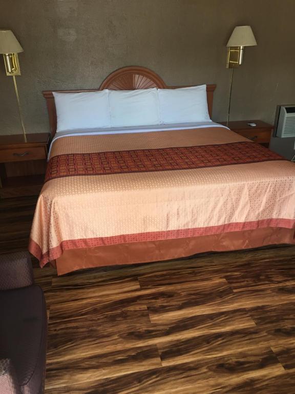 a bedroom with a large bed with white pillows at Hilltop Inn in Franklin