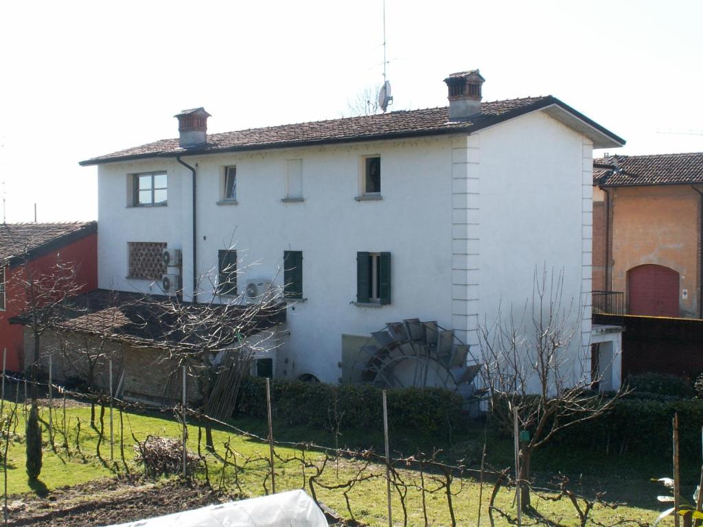 una vieja casa blanca con una valla delante en Molino Antico, en Soncino